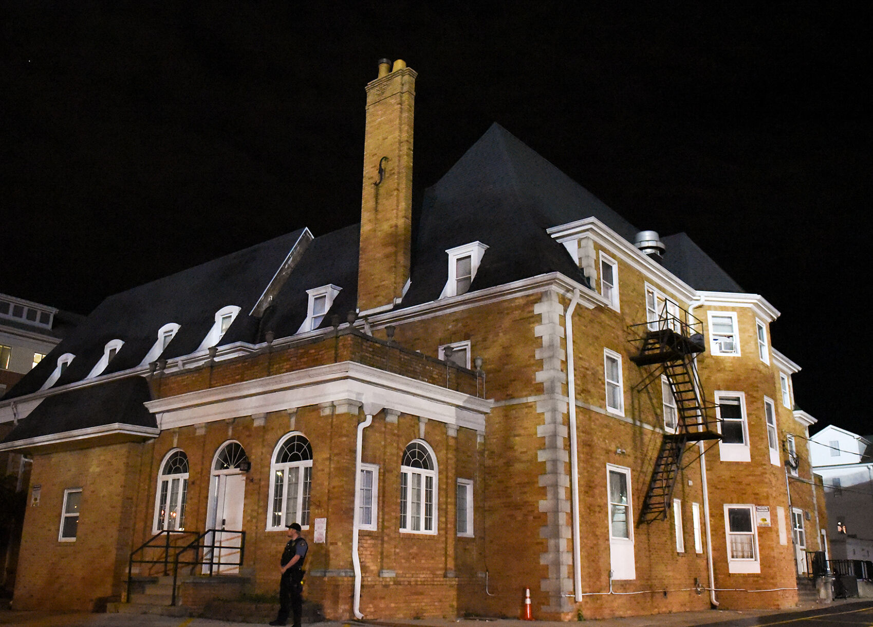 A police officer stands at the corner of the Phi Gamma Delta fraternity house